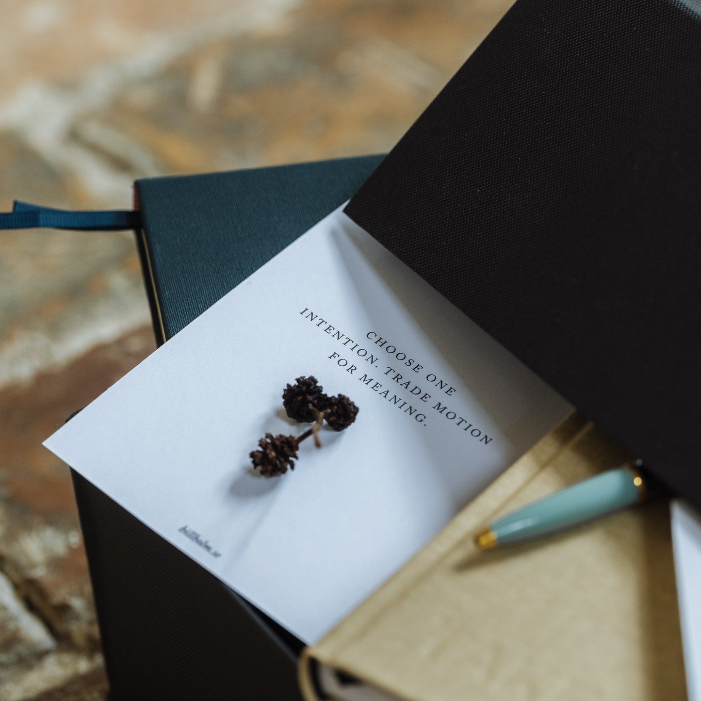 Open book with a pen and decorative elements on a textured surface