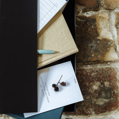 Notebooks, pen, and stationery items on a textured stone surface
