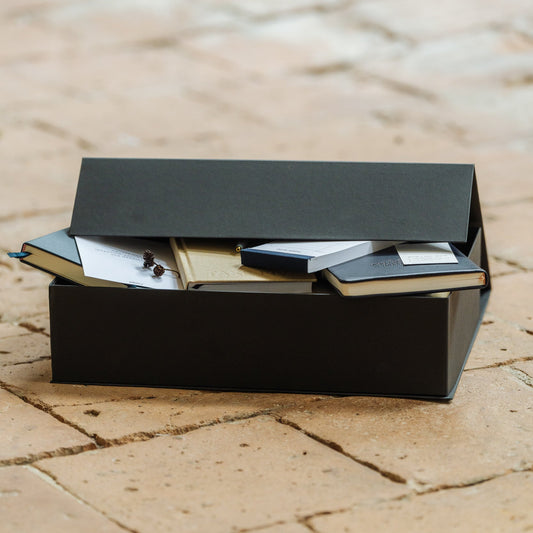 Black box with items on a textured stone surface